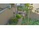 Exterior view of a condo building with landscaped walkway, tropical plants, and stairs to upper units at 107 Woodland Pl # 107, Osprey, FL 34229