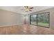 Living room featuring tile floors, a ceiling fan, and sliding glass doors leading to a screened lanai at 107 Woodland Pl # 107, Osprey, FL 34229