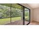 Screened lanai with tile flooring, providing a view of a lush, green landscape at 107 Woodland Pl # 107, Osprey, FL 34229
