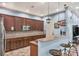 Stylish kitchen area with brown cabinets, a breakfast bar, tiled backsplash, and modern appliances at 11507 84Th Street E Cir # 102, Parrish, FL 34219
