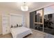 Bright bedroom showcasing a neatly made murphy bed flanked by shelving, with expansive windows offering city views at 1155 N Gulfstream Ave # 406, Sarasota, FL 34236
