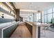 Modern kitchen features bar top seating, sleek countertops, and contemporary pendant lighting fixtures at 1155 N Gulfstream Ave # 406, Sarasota, FL 34236