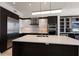 Modern kitchen with stainless steel appliances, island, two-tone cabinets and a mosaic backsplash at 1155 N Gulfstream Ave # 406, Sarasota, FL 34236