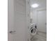 Clean laundry room featuring a modern washer and dryer, white cabinets, and a louvered door for ventilation at 1155 N Gulfstream Ave # 406, Sarasota, FL 34236