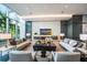 Bright living room features modern sofas, recessed lighting, and expansive windows showcasing tropical landscaping at 1155 N Gulfstream Ave # 406, Sarasota, FL 34236