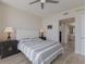Bedroom with a ceiling fan and a tufted headboard and doorway to bathroom at 1155 N Gulfstream Ave # 406, Sarasota, FL 34236