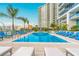 Inviting pool area featuring a sparkling blue pool, comfortable lounge chairs, and lush palm trees at 1155 N Gulfstream Ave # 406, Sarasota, FL 34236