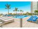 Luxurious pool area featuring modern lounge chairs, tall palm trees and a clear blue swimming pool at 1155 N Gulfstream Ave # 406, Sarasota, FL 34236