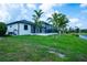 Side view shows the home's screened-in pool and spa and a view of the canal at 117 Marker Rd, Rotonda West, FL 33947