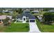 Aerial shot of a modern two-story home with a paved driveway, manicured lawn, and mature landscaping at 117 Marker Rd, Rotonda West, FL 33947