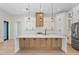 Open kitchen with white cabinets, a large island, stainless steel appliances, and modern pendant lighting at 117 Marker Rd, Rotonda West, FL 33947