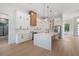 Beautiful kitchen with stainless steel appliances, white cabinets, a large island and hardwood floors at 117 Marker Rd, Rotonda West, FL 33947