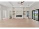 Open-concept living room with fireplace, floating shelves, and light wood floors at 117 Marker Rd, Rotonda West, FL 33947