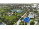 Aerial view features park amenities, including tennis courts, picnic shelters, and playground amidst lush greenery at 12183 Longview Lake Cir, Bradenton, FL 34211