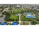 Aerial perspective highlighting a park with playgrounds, tennis courts, shaded seating, and landscaped pathways for community enjoyment at 12183 Longview Lake Cir, Bradenton, FL 34211
