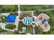 Overhead view of a park's playground with splash pad, picnic area, and covered structure amidst palm trees and landscaping at 12183 Longview Lake Cir, Bradenton, FL 34211