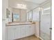 Bright bathroom featuring a double sink vanity and a glass enclosed shower at 12183 Longview Lake Cir, Bradenton, FL 34211