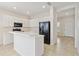 Well-lit kitchen features white cabinetry, black appliances, a breakfast bar, and tiled floors at 12183 Longview Lake Cir, Bradenton, FL 34211