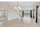 Open-concept living room with tile flooring, a chandelier, and views of the scenic backyard pond at 12183 Longview Lake Cir, Bradenton, FL 34211