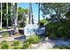 Inviting entrance to Gulf & Bay Club Bayside with lush landscaping and glimpse of the community's charming architecture at 1226 Siesta Bayside Dr # 1226C, Sarasota, FL 34242