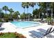 Community pool with lounge chairs and umbrellas, surrounded by lush landscaping and mature palm trees at 1226 Siesta Bayside Dr # 1226C, Sarasota, FL 34242