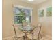 Cozy dining area featuring a glass-top table, wicker chairs, and a window with natural light at 1226 Siesta Bayside Dr # 1226C, Sarasota, FL 34242