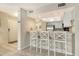 Kitchen bar with three barstools and decorative starfish hanging overhead, overlooking the entryway at 1226 Siesta Bayside Dr # 1226C, Sarasota, FL 34242