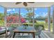 The screened lanai has a table and chairs, ceiling fan and a colorful view of the surrounding landscaping and tennis courts at 1226 Siesta Bayside Dr # 1226C, Sarasota, FL 34242