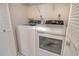 A clean laundry room with a washer and dryer with white cabinets at 1226 Siesta Bayside Dr # 1226C, Sarasota, FL 34242