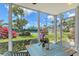 Enclosed patio featuring a cozy dining area with a serene view of the tennis court and gardens at 1226 Siesta Bayside Dr # 1226C, Sarasota, FL 34242