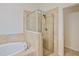Modern bathroom featuring tiled walls, glass shower, and soaking tub at 148 Wandering Wetlands Cir, Bradenton, FL 34212