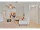 Open-concept living room with tile flooring, ceiling fan, and kitchen access at 148 Wandering Wetlands Cir, Bradenton, FL 34212