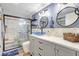 Contemporary bathroom with blue accent wall, glass shower, and elegant vanity with decorative mirrors at 1489 18Th St, Sarasota, FL 34234