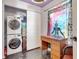 This laundry room features a stacked washer and dryer, storage, and a vintage desk area at 1489 18Th St, Sarasota, FL 34234
