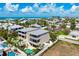 Stunning aerial view of a coastal home with a private pool, lush landscaping, and balconies overlooking the ocean at 215 65Th St, Holmes Beach, FL 34217