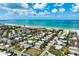 Breathtaking aerial view of the coastline, showcasing the house in close proximity to the white sand beach and turquoise waters at 215 65Th St, Holmes Beach, FL 34217