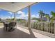 Covered balcony with a seating area, ceiling fan, and a view of lush landscaping at 215 65Th St, Holmes Beach, FL 34217
