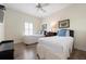 This bedroom features two twin beds, wood floors, a ceiling fan, and a window with shutters at 215 65Th St, Holmes Beach, FL 34217