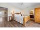 A well-lit bedroom features a wooden bed frame, wood floors and an ensuite bathroom at 215 65Th St, Holmes Beach, FL 34217