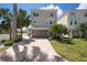 Charming two-story home with a brick driveway and well-manicured landscaping, creating a welcoming curb appeal at 215 65Th St, Holmes Beach, FL 34217