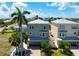 Charming three-story home with a covered porch, a well-maintained lawn and tropical landscaping, and a stylish exterior at 215 65Th St, Holmes Beach, FL 34217