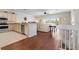 Open-concept kitchen flowing into the living area, featuring stainless steel appliances and hardwood floors at 215 65Th St, Holmes Beach, FL 34217