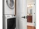Convenient laundry area with a stacked washer and dryer and a glimpse of the nearby bathroom at 215 65Th St, Holmes Beach, FL 34217