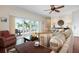 A comfortable living room with a ceiling fan, sliding glass doors to a balcony, and a striped sofa at 215 65Th St, Holmes Beach, FL 34217