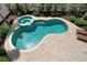 An aerial view shows a kidney shaped pool and jacuzzi surrounded by white fence and a paver patio at 215 65Th St, Holmes Beach, FL 34217