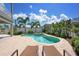 Sparkling backyard pool and spa with lounge chairs, framed by tropical landscaping and a sunny sky at 215 65Th St, Holmes Beach, FL 34217
