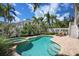 Beautiful backyard pool with an attached spa area and patio, surrounded by lush landscaping, perfect for relaxing at 215 65Th St, Holmes Beach, FL 34217