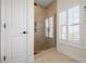 This bathroom features a glass shower with a window and shutter, plus a tile floor and wall at 215 65Th St, Holmes Beach, FL 34217