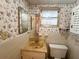 A bathroom featuring floral wallpaper, a mirror over a vanity and a white toilet at 237 Blackburn Blvd, North Port, FL 34287