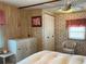 A cozy bedroom with wood paneled walls, floral wallpaper, and bright natural light at 237 Blackburn Blvd, North Port, FL 34287